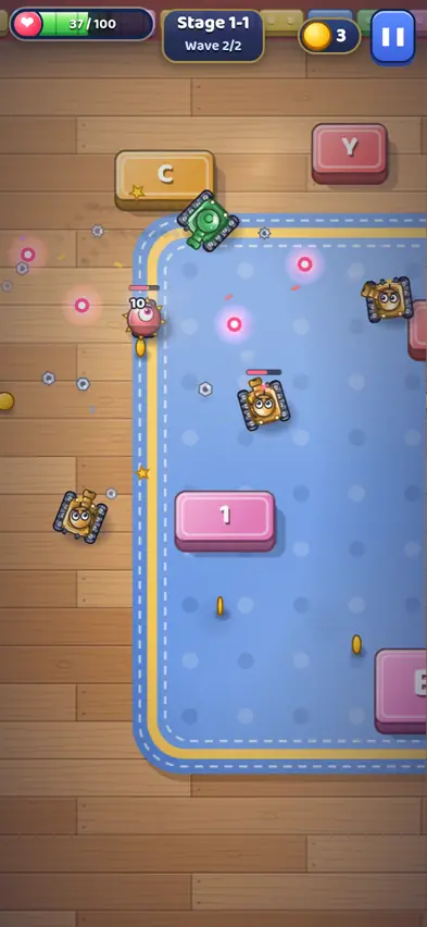 A green toy tank on a blue play mat between toy letter blocks, with orange robot tanks and a pink robot firing glowing shots, health at 37 of 100 in wave 2 of 2